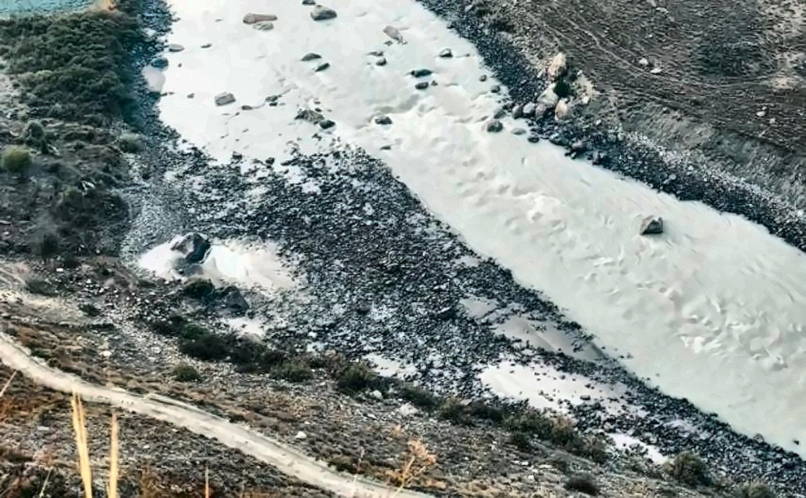 Milky glacial river running through a rocky valley